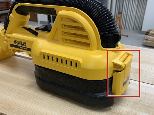 Unlatch the yellow latch on the backside of the vacuum.
