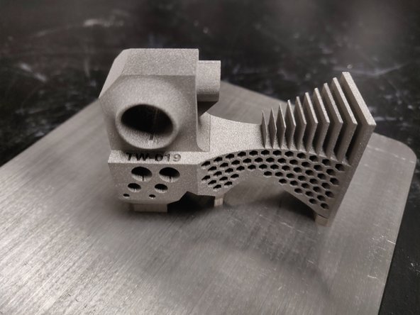 Pound build plate on tabletop to loosen powder in through holes and support material