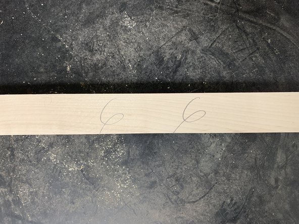 Apply weight onto outfeed end of the board once board passes cutting head.