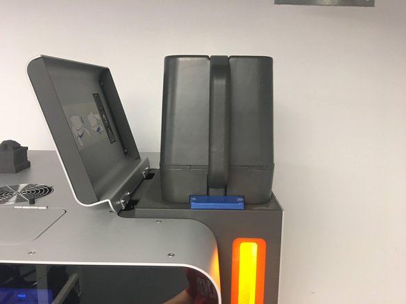 Using two hands, hold the handles of the Powder Bin, and use your thumbs to press the blue latches outwards while lifting the Powder Bin upwards to remove the Bin