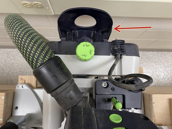 To angle the miter saw, flip up the cover on the back of the saw.