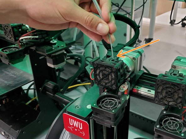 Once your filament has been pushed all the way through the PTFE tube, push your filament down the hole in the extruder motor until it can not go any farther