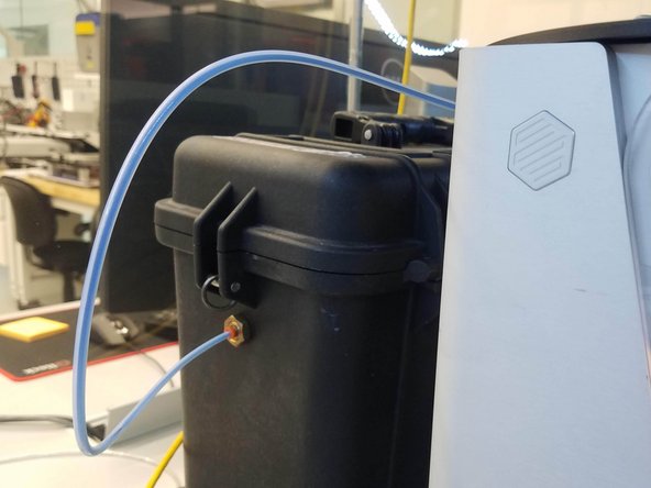 Insert one end of the plastic feed tube into the adapter on the side of the drybox