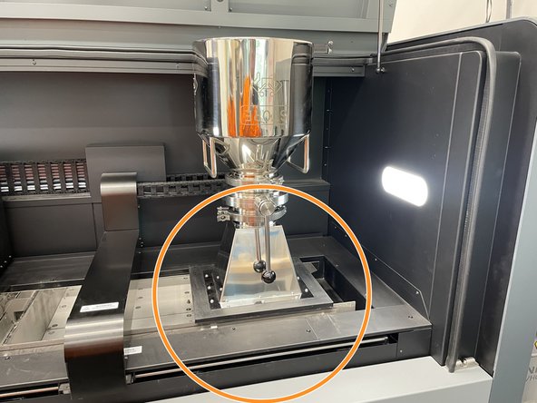 With two people, lift and align the powder keg + funnel onto the powder feeder