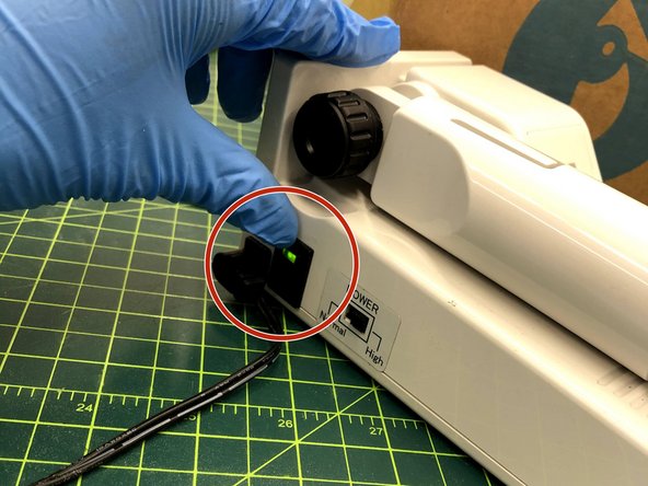 Flip the side switch and press the white button on the handle to turn it on