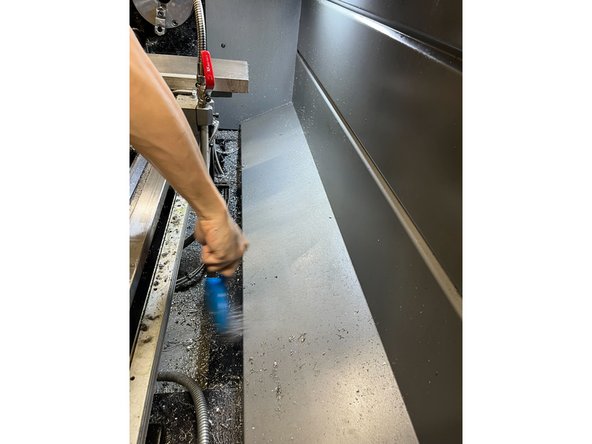 Continue to use the steel wire brush to brush the chips off the back of the wall into the tray underneath