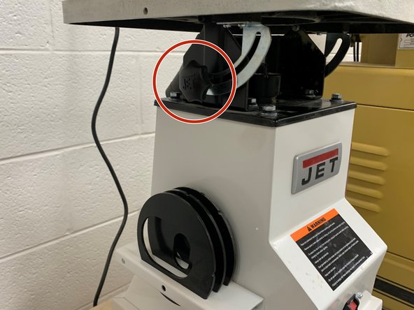 To adjust the angle of the table, loosen both adjustment knobs on either side of the table