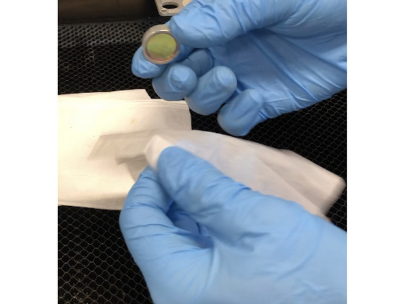 Gently slide the lens off the lens tool. Wipe both sides with a Zeiss wipe.