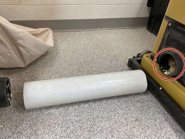 Hold bag over sawdust bin and shake out until empty.