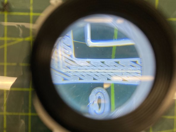 Use the illuminated magnifier stored in the canister bay door to inspect the outer box of the calibration part