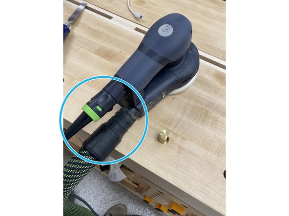 Plug in the power cable and the vacuum hose to the hand sander. The vacuum hose may be difficult to get on, but it should be pushed all the way onto the sander to prevent leakage.