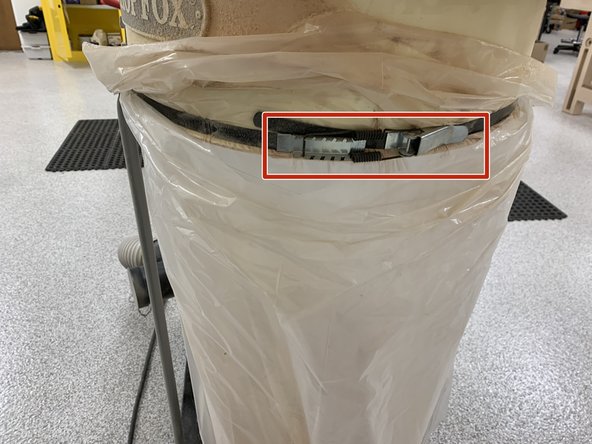 Undo metal latch holding the metal ring around the beige body.