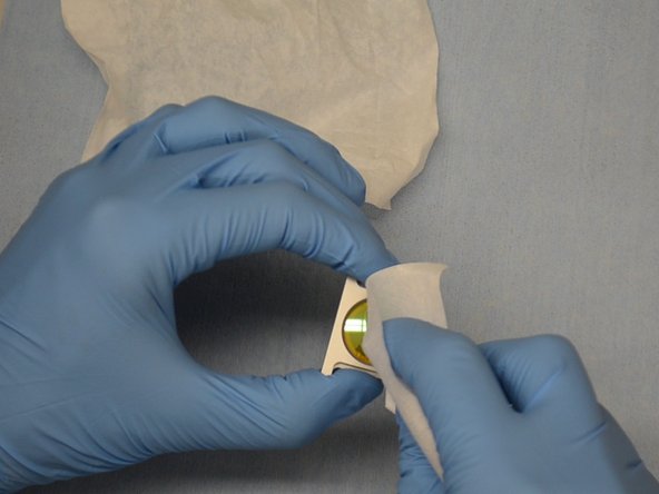 Lightly wipe the lens spiraling out from the center.