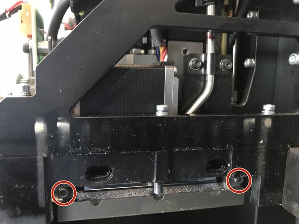 While supporting the bottom of the roller bath, unscrew the two screws circled