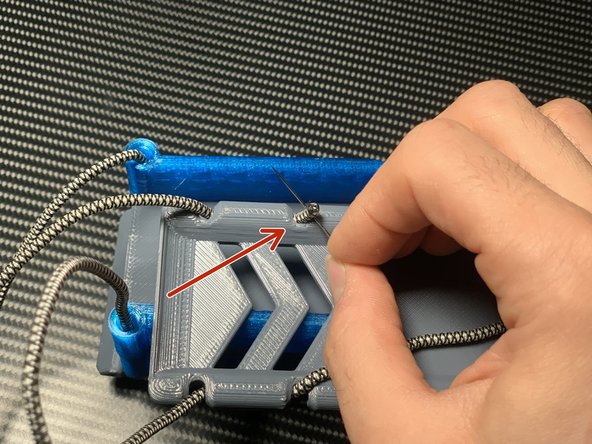 Pull the cord through the second set of holes on the front plate. You may need to use your pin.