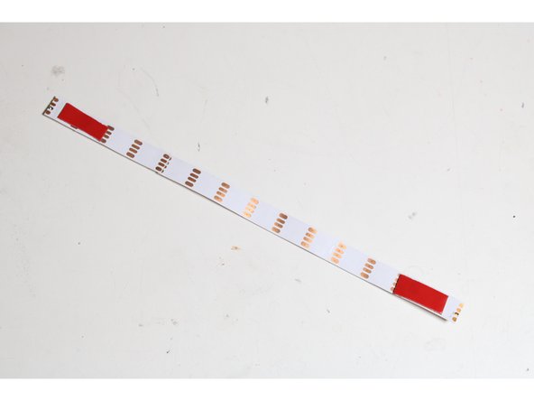 Use some heat-tolerant double-stick tape to mount a strip to the center of each aluminum segment.