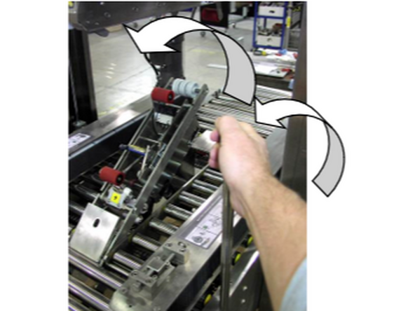 2-Pull the bottom tape head holder lever towards you to rotate the bottom head up and out of the bottom machine frame. The lever has a latching pin to secure it in the up position.