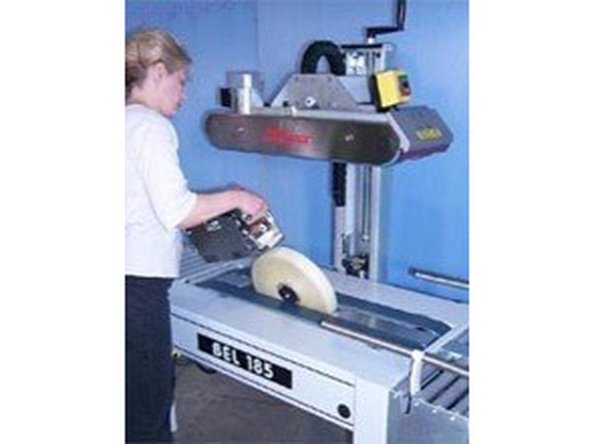 Tape dispensing heads are mounted with pins on their sides that fit into corresponding slots in the upper and lower tape-head mounting positions.