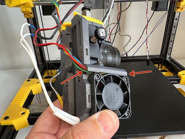 Hold the hotend thermistor and heater cartridge cables as seen in the picture.