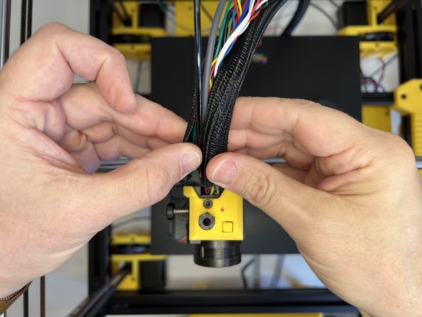 Insert the 3mm nylon filament and tuck the cable harness in the cable sleeve.