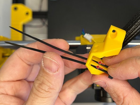 Insert two zip ties through the slots on the Cable Harness Holder.