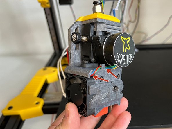 Make sure the motor cable passed behind the bulge and under the cable canal over the extruder fan on the previous step.