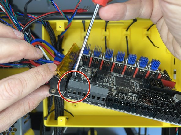 Before fixing the mainboard, loosen the flat screws on the first two terminals for the hotend heater cartridge.