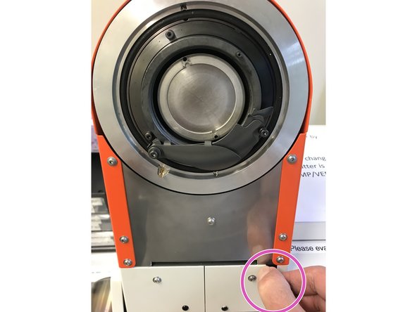 Take the orange sputter head in both hands and mount it on the device.