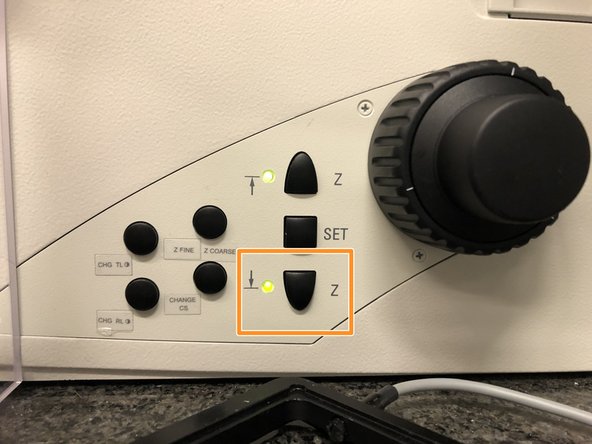 Lower the objective turret by pressing the downwards &quot;Z&quot; button on the right side of the microscope.