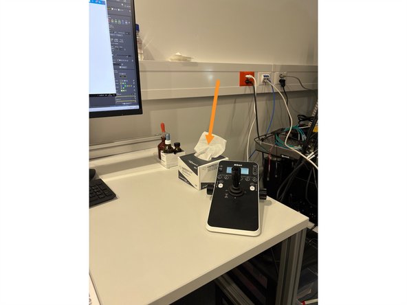 Take the KIMTECH tissue and blot the objective gently with a tissue to dry it.