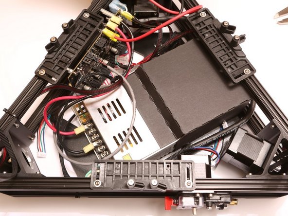 Holding the PSU, flip the lower triangle over and secure the PSU in place with 4x M4 FSC, included in the PSU Kit.