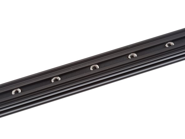 Slide nuts and nut spacers into the OpenBeam extrusion's T-Slot.