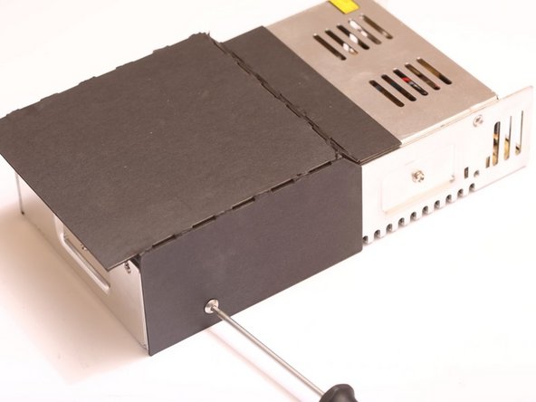 The cardboard duct redirects the cooling air from the cooling exhaust fan out the side of the printer.  Without this duct, the cooling air will blow up directly at the heated bed, causing a cold spot to form on the HBP.