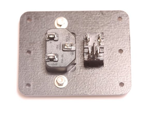 Secure IEC Power inlet with an M3 x 10mm FSC screw, a fender washer, and a nyloc nut, as shown to the right.