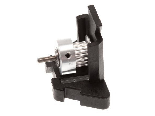 Insert an M3 30mm SHC Screw into the Idler Subassembly Front/Back, then slide a pulley onto it with the thick end facing the narrow side of the Idler Subassembly Top/Bottom.